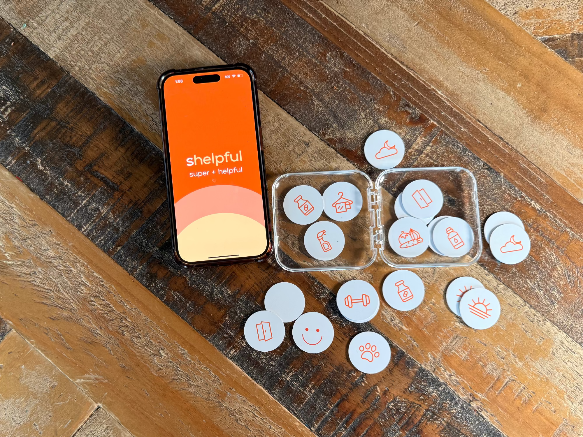 Phone displaying 'shelpful' app on a wooden surface with circular icons.