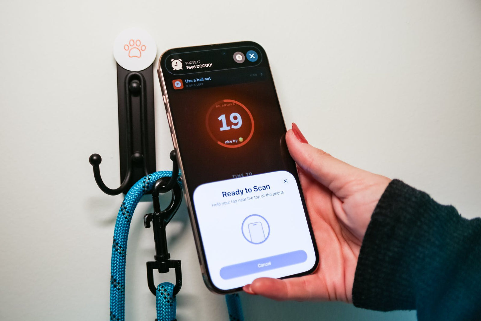 Tapping the phone to a paw sticker by the dog leash hook